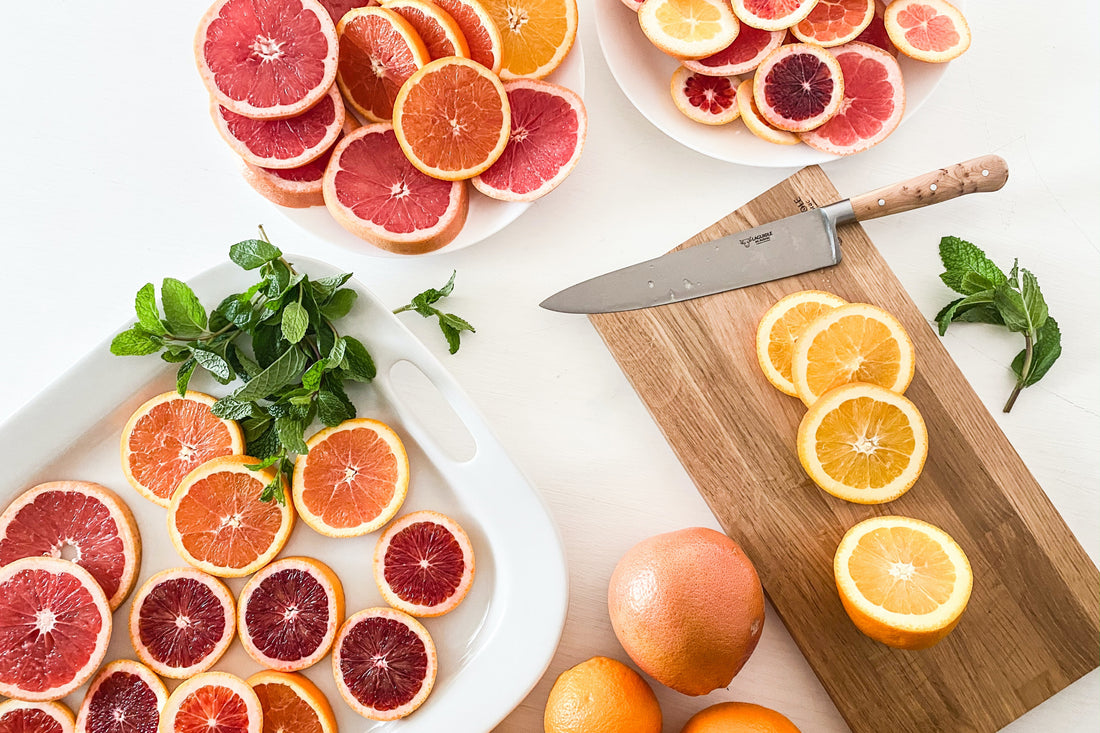 citrus fruits on a cutting board with knife